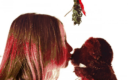 Dziewczynka całuję misia pod jemiołą